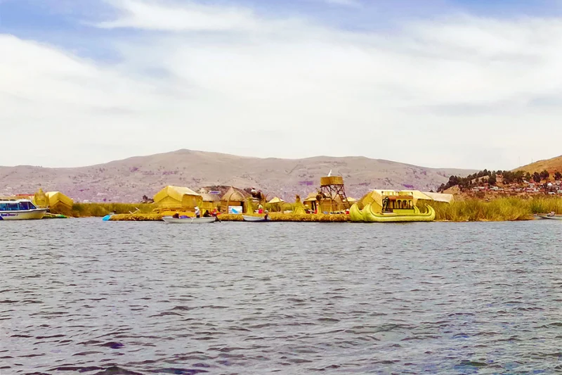 Lake Titicaca day tour boat arriving at the Uros floating islands from Puno
